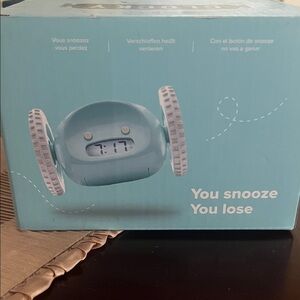 Blue Alarm Clock on Wheels